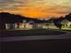 Expansive white home at dusk with a well manicured lawn and a beautiful sky overhead at 1169 Hodges Cir, Mansfield, GA 30055