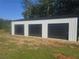 Large, three-door garage with metal siding offers ample storage and workspace at 1169 Hodges Cir, Mansfield, GA 30055