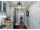 Hallway featuring rustic cabinets, stainless steel refrigerator and laundry room entrance, with wood floors and modern light fixture at 1169 Hodges Cir, Mansfield, GA 30055