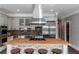 Butcher block island with cooktop and hood, stainless steel appliances, and custom cabinets with brick backsplash at 1169 Hodges Cir, Mansfield, GA 30055