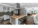 Gourmet kitchen with island cooktop, stainless appliances, bar stool seating and adjacent living area at 1169 Hodges Cir, Mansfield, GA 30055