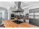 Gourmet kitchen boasting butcher block island, stainless appliances, and custom cabinetry with brick backsplash at 1169 Hodges Cir, Mansfield, GA 30055