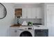 Laundry room with white cabinets, wood counters, shelving, and stainless steel washer and dryer units at 1169 Hodges Cir, Mansfield, GA 30055