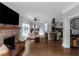 Open-concept living space with hardwood floors, brick fireplace, and seamlessly connected kitchen and dining area at 1169 Hodges Cir, Mansfield, GA 30055
