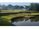 Beautiful waterfront property featuring a serene pond and a home with manicured lawns and mature trees at 1169 Hodges Cir, Mansfield, GA 30055