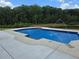 Beautiful in-ground pool with a concrete surround, complete with water features in a large backyard at 1169 Hodges Cir, Mansfield, GA 30055