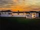 Expansive white home at sunset with a long raised patio and lawn down to the hillside at 1169 Hodges Cir, Mansfield, GA 30055