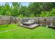 Manicured backyard featuring a sunbed lounge area, privacy fencing, and lush green lawn at 3246 Spicy Cedar Ln, Lithonia, GA 30038