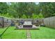 Manicured backyard featuring a sunbed lounge area, privacy fencing, and lush green lawn at 3246 Spicy Cedar Ln, Lithonia, GA 30038