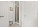 All-white bathroom featuring a glass-enclosed shower and light tile floors at 3246 Spicy Cedar Ln, Lithonia, GA 30038