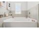 Clean white bathtub is surrounded by ceramic tiling and light from a bright window at 3246 Spicy Cedar Ln, Lithonia, GA 30038