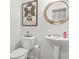 Elegant half-bathroom featuring a modern pedestal sink, decorative mirror, and stylish accents at 3246 Spicy Cedar Ln, Lithonia, GA 30038