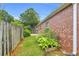Charming home exterior with lush greenery, manicured lawn and brick detail along the backyard at 401 Buckboard Ln, Locust Grove, GA 30248