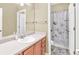 Bright bathroom featuring a shower with floral curtain and a vanity with a large mirror at 401 Buckboard Ln, Locust Grove, GA 30248