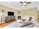 Bright living room featuring a fireplace, mounted television, and comfortable sectional sofa at 401 Buckboard Ln, Locust Grove, GA 30248