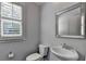 Elegant half-bathroom with a decorative mirror and pedestal sink at 5965 Vista Brook Dr, Suwanee, GA 30024