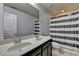 Bright bathroom features a double sink vanity and striped shower curtain at 5965 Vista Brook Dr, Suwanee, GA 30024