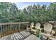 Wooden deck with three plastic chairs and a view of the backyard at 5965 Vista Brook Dr, Suwanee, GA 30024