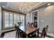 Stunning dining room with a wooden table, chandelier, and window with shutter-style blinds creating a sophisticated ambiance at 5965 Vista Brook Dr, Suwanee, GA 30024