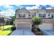 Beautiful townhome featuring a stone and gray siding facade with a well-maintained lawn and a two-car garage at 5965 Vista Brook Dr, Suwanee, GA 30024