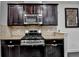 The kitchen showcases stainless steel appliances, dark cabinets, and granite countertops at 5965 Vista Brook Dr, Suwanee, GA 30024