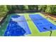 A view of the blue and green community tennis courts surrounded by mature trees at 5965 Vista Brook Dr, Suwanee, GA 30024