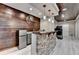 Wet bar with a mini-fridge, stone counter, wood backsplash, and views to home gym at 5965 Vista Brook Dr, Suwanee, GA 30024