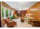 A spacious room with wood paneling, a brick fireplace, and a view of the wooded backyard at 1103 Lee Ne Cir, Atlanta, GA 30324
