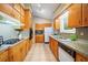 Traditional kitchen with wood cabinets, granite countertops, tile flooring, and appliances at 1103 Lee Ne Cir, Atlanta, GA 30324