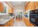 Galley kitchen featuring wooden cabinetry, granite countertops, tile flooring, and stainless steel sink at 1103 Lee Ne Cir, Atlanta, GA 30324