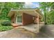 Rear exterior view of a brick home with a covered patio and lush, natural surroundings at 1103 Lee Ne Cir, Atlanta, GA 30324