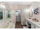 Luxurious bathroom showcasing a chandelier, jacuzzi tub, and mirrored vanity at 3711 Frey Lake Nw Rd, Kennesaw, GA 30144