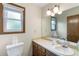 Well-lit bathroom featuring a single sink vanity and wood framed mirror and window at 3711 Frey Lake Nw Rd, Kennesaw, GA 30144