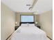 Bedroom featuring a queen bed, window, bedside lamps, and neutral walls at 3711 Frey Lake Nw Rd, Kennesaw, GA 30144