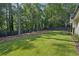 Large backyard features lush green grass, mature trees, and a privacy fence at 477 Michael Dr, Alpharetta, GA 30009