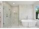 A modern bathroom showcases a glass shower with seating and soaking tub beneath a bright window at 477 Michael Dr, Alpharetta, GA 30009