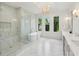 A stunning bathroom with a glass shower, freestanding tub, marble floors, and a decorative chandelier at 477 Michael Dr, Alpharetta, GA 30009