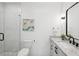 Modern bathroom featuring sleek white tiles, glass shower, and marble countertop at 477 Michael Dr, Alpharetta, GA 30009
