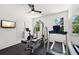 Home gym with rubber flooring, TV, ceiling fan, and plenty of workout equipment at 477 Michael Dr, Alpharetta, GA 30009
