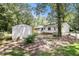 Spacious backyard with a storage shed, surrounded by mature trees and grass at 60 Ivy Dr, Covington, GA 30016
