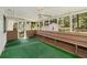 Screened-in porch featuring green carpet, built in wooden bench seats, and a ceiling fan at 60 Ivy Dr, Covington, GA 30016