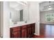Bathroom with a double sink, cherry cabinets, and access to the main bedroom at 915 Pebble Creek Trl, Suwanee, GA 30024