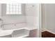 Bathroom with a soaking tub, white tiled wall, and window at 915 Pebble Creek Trl, Suwanee, GA 30024
