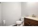 Powder room featuring a toilet, single sink vanity, and dark wood-look flooring at 915 Pebble Creek Trl, Suwanee, GA 30024