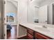 Bright bathroom features a vanity with dark wood cabinets, white countertop, and a view into the connected bedroom at 915 Pebble Creek Trl, Suwanee, GA 30024