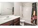 Bathroom featuring a shower-tub combo, toilet, single sink vanity, and dark wood-look flooring at 915 Pebble Creek Trl, Suwanee, GA 30024