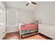 Cozy bedroom features wood floors, white trim, a ceiling fan and a window with blinds at 915 Pebble Creek Trl, Suwanee, GA 30024