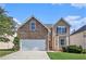Charming two-story home featuring a stone facade, attached garage, and well-maintained lawn on a sunny day at 915 Pebble Creek Trl, Suwanee, GA 30024