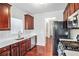 Well-lit kitchen with stainless steel appliances, white countertops and stylish cherry cabinets at 915 Pebble Creek Trl, Suwanee, GA 30024