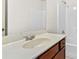 Bathroom vanity featuring a large mirror, white countertop, and dark wooden cabinets at 1492 Station Ridge Ct, Lawrenceville, GA 30045